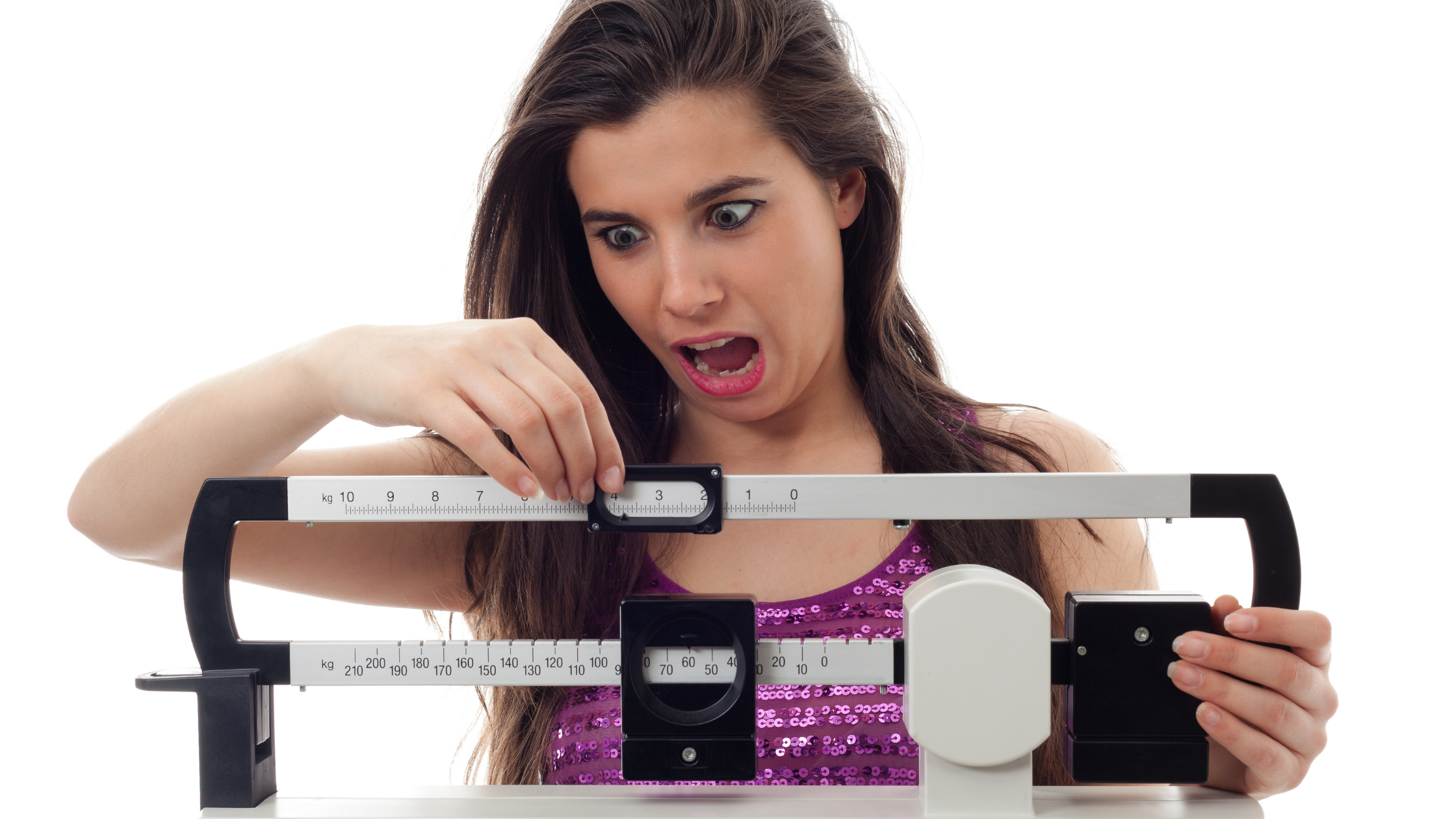 Woman on scale is shocked by weight gain