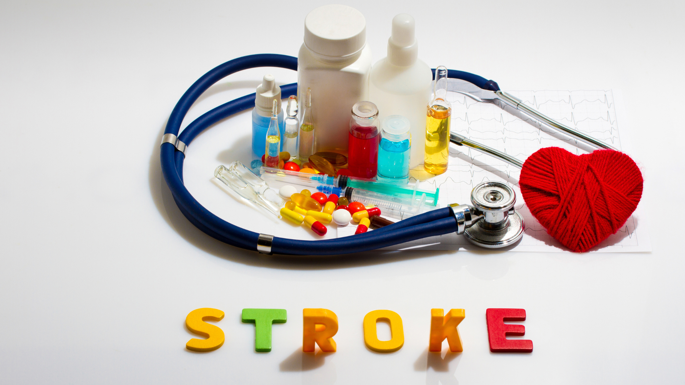 block letters spell out "STROKE" in front of a stethoscope and colorful medications