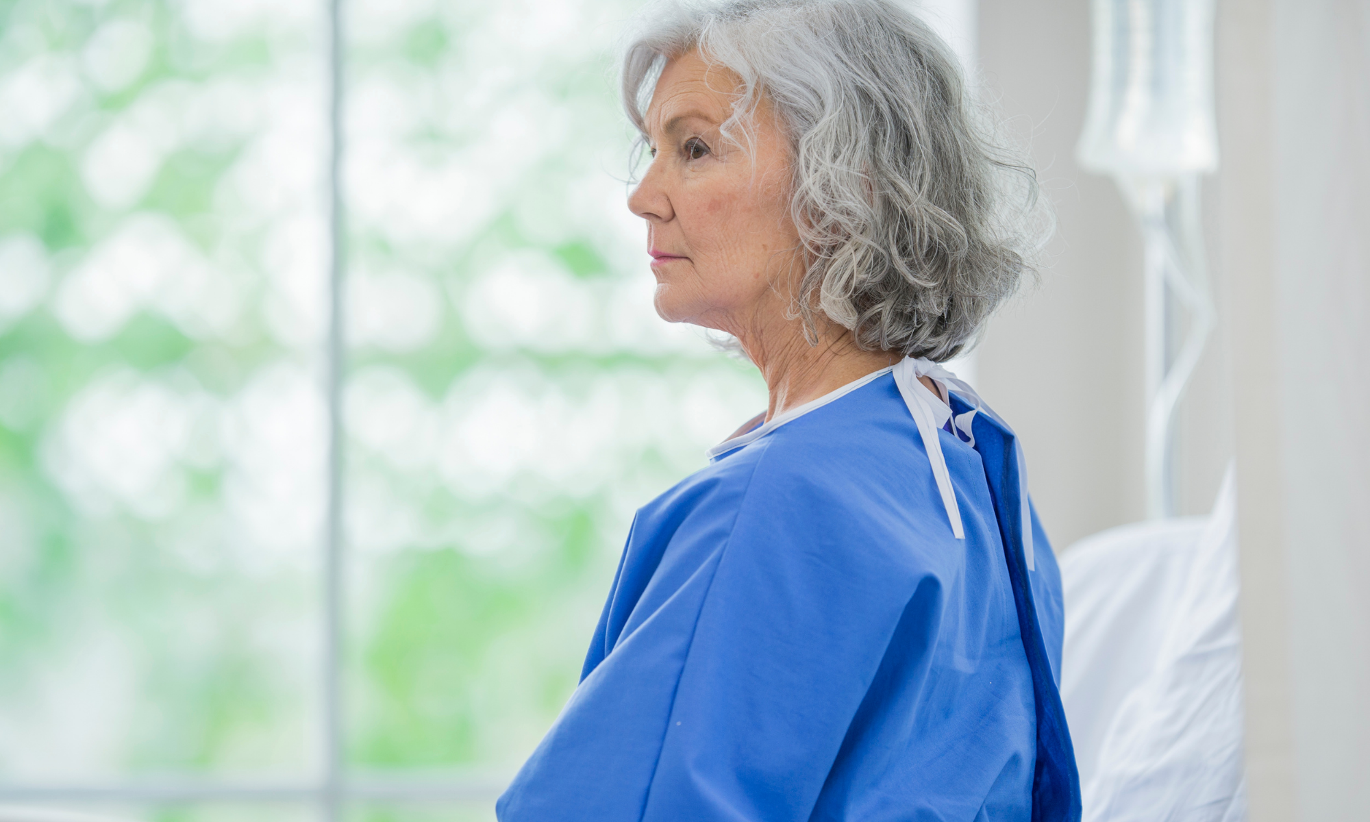 Older woman in medical robe looks into the mid-distance 