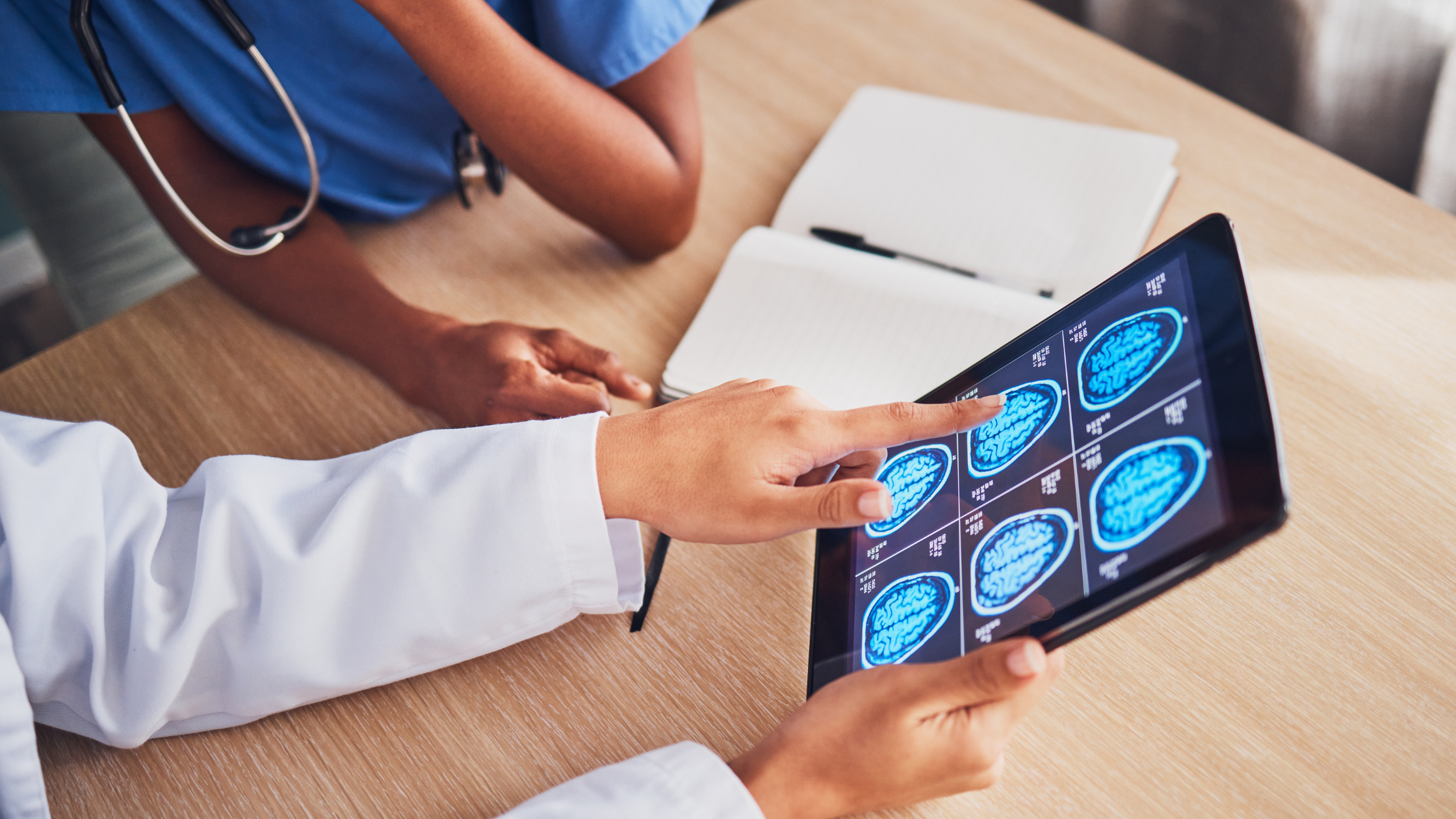 doctor holding a tablet and pointing to a brain scan