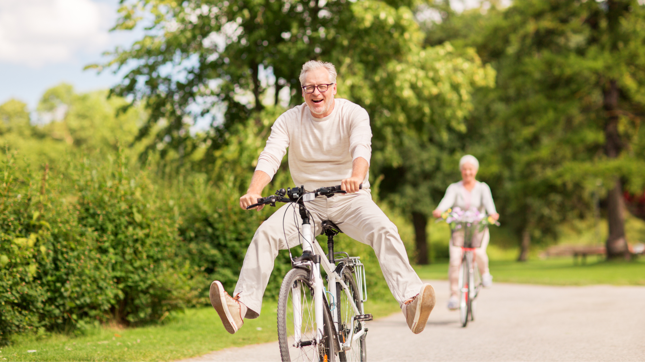 senior man grins while riding a bike on a sunny day senior man grins while riding a bike on a sunny day